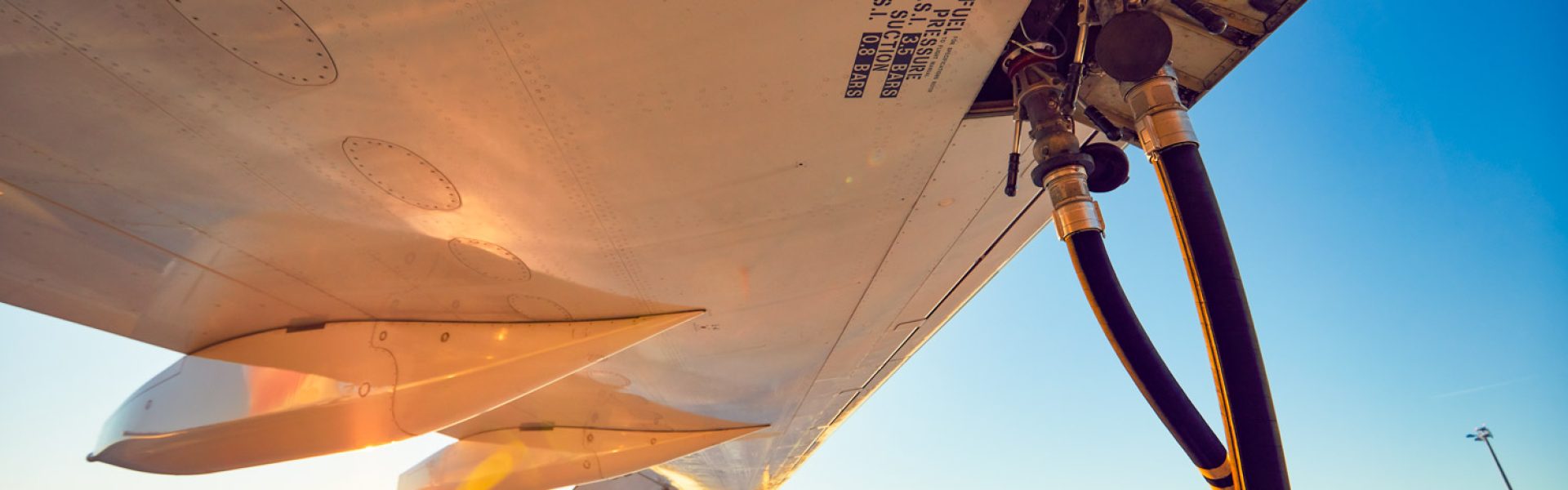 Amazing sunset at the airport. Refueling of the airplane before flight.