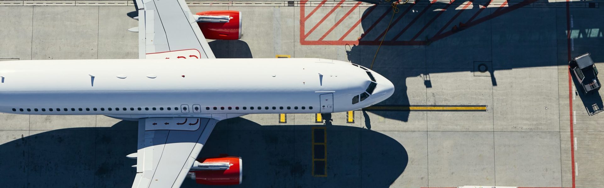 Aerial view of airport. Airplane is taxiing to gate of terminal.