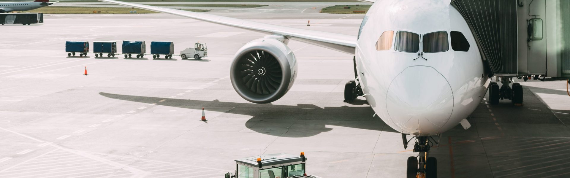 Aircraft Plane Boarding Passengers In Airport Terminal. Aircraft Tow Tractor And Fright Forklift Near Plane.
