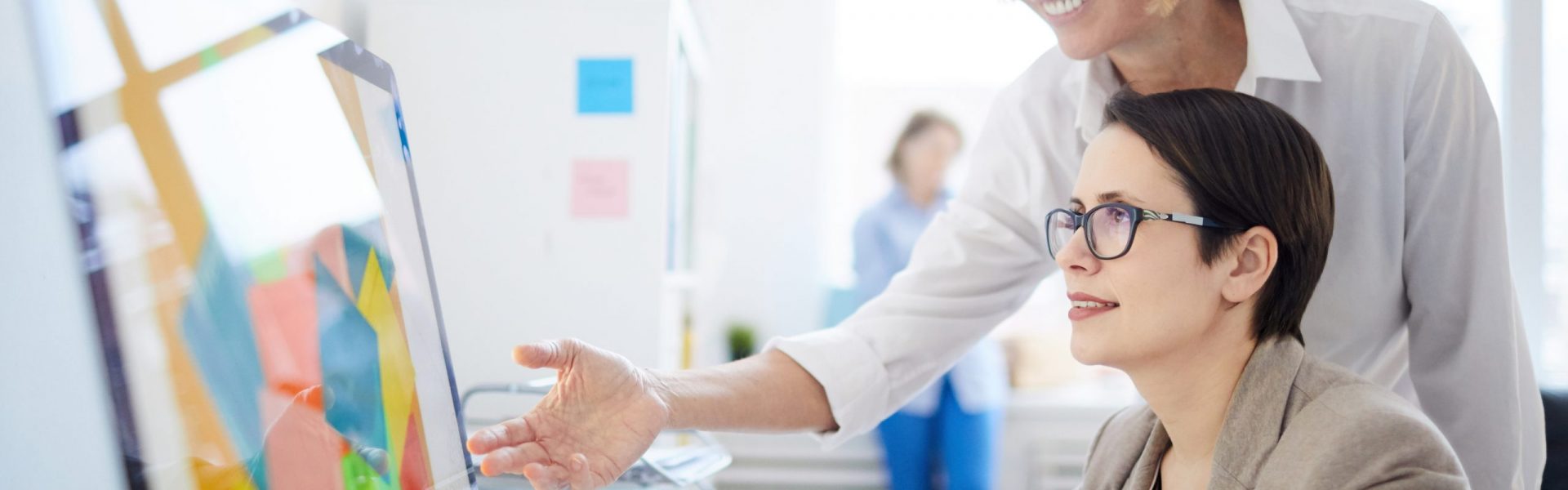 Side view portrait of two businesswomen using computer in design agency